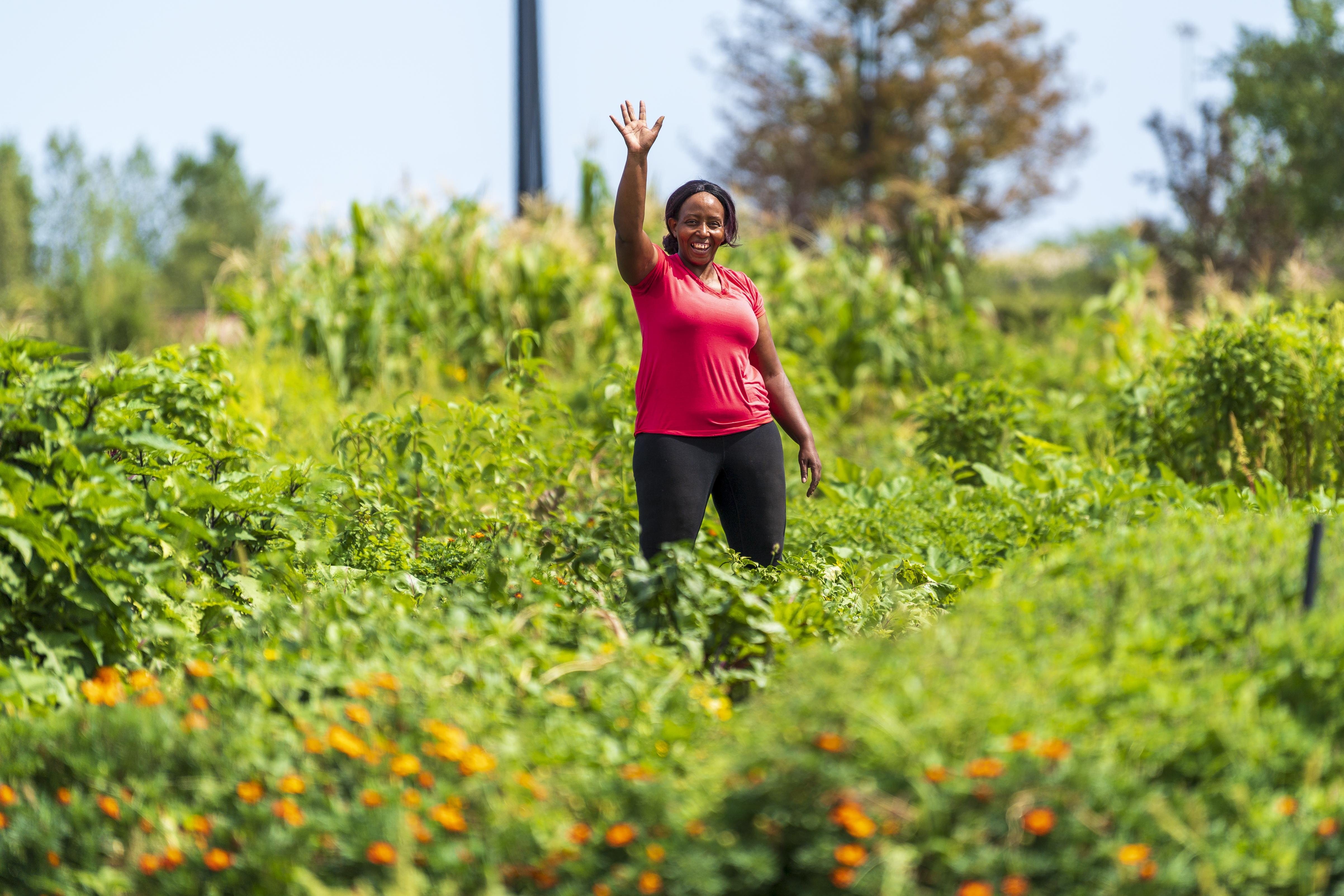 Woman stands waving in a field 